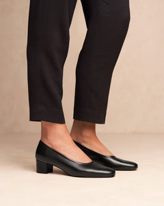 Oya Culford classic black, low heel women's shoes for extended sizes, model wearing with black trousers for office work look.